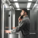 a person in an elevator talking on a phone